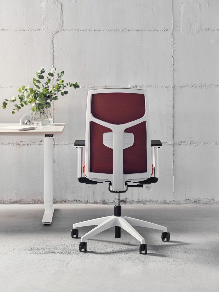 Fauteuil ergonomique blanc et rouge avec bureau professionnel en fond clair